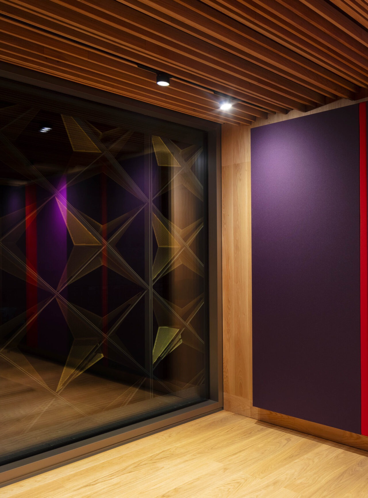 Ausßenwand wird von Deckenstrahlern angeleuchtet. Moderne Architekturbeleuchtung mit Stromschienen und Einbauleuchten von mawa im Haus für Musik, Potsdam. Proberaumbeleuchtung, Konzertraumbeleuchtung im akustisch optimierten Proberaum des Hauses für Musik, Potsdam